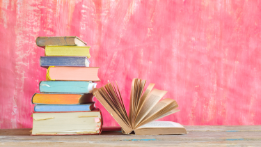 Stack of books beside an open book