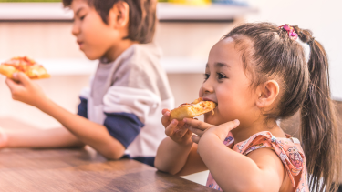 Girl and boy eating pizza