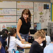 Teacher smiling at her students who sit at their desks