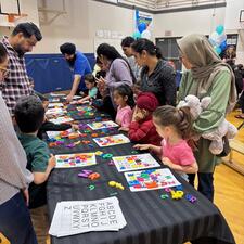 Parents and young children doing puzzles together at a table.