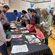 Parents and young children doing puzzles together at a table.