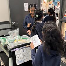 Students gather around a cart to hand out prizes.