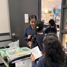 Students gather around a cart to hand out prizes.